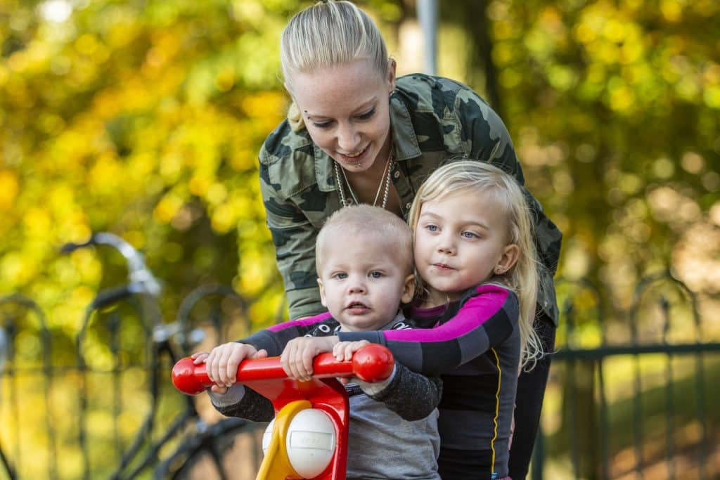 Moeder en kinderen spelen in park